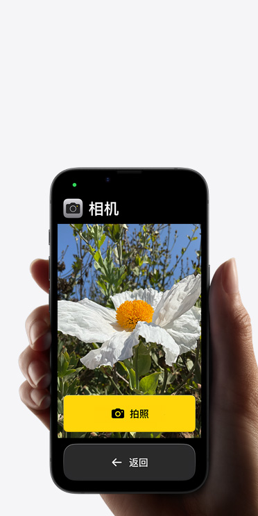 iPhone 16e 屏幕显示精简的相机 app 界面，包括取景画面中的白色花朵、“拍照”按钮及其下方的“返回”按钮。
