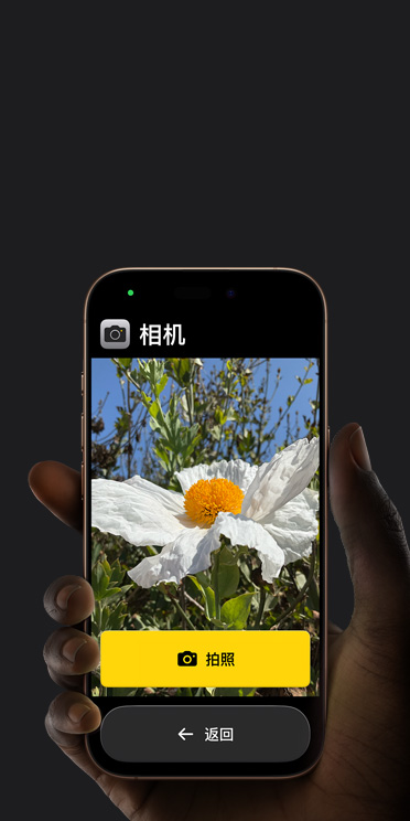iPhone 16 Pro 屏幕显示精简的相机 app 界面，包括取景画面中的白色花朵、“拍照”按钮及其下方的“返回”按钮。