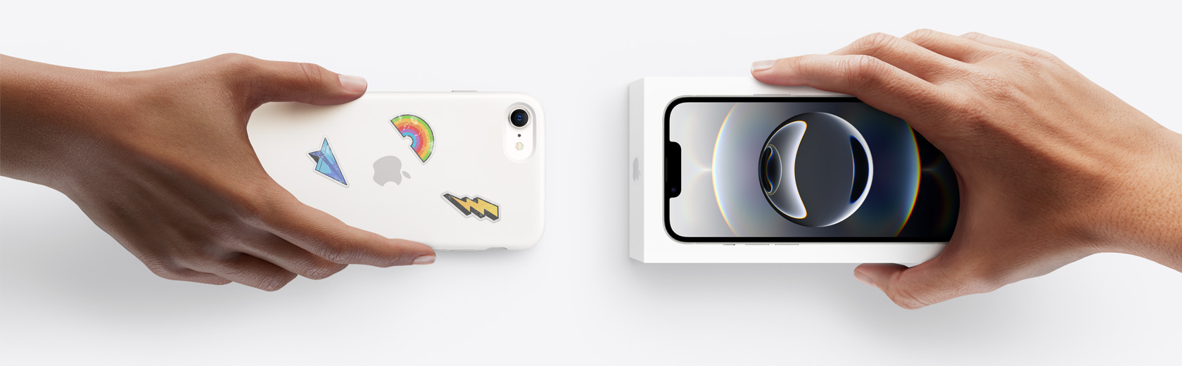 一只手拿着一部用于换购的 iPhone,换取另一只手中未拆封的 iPhone 16e。